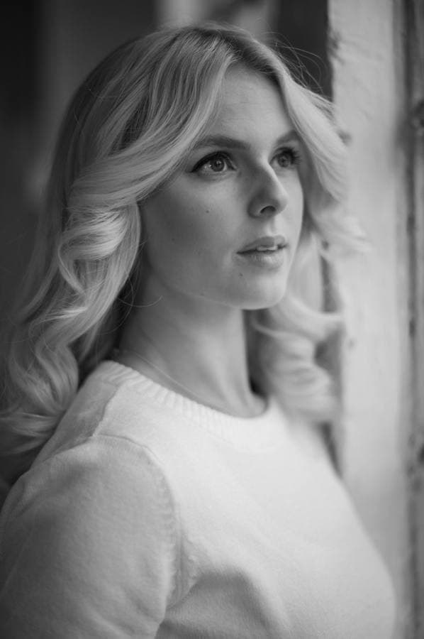 Portrait in a white blouse, plain background.